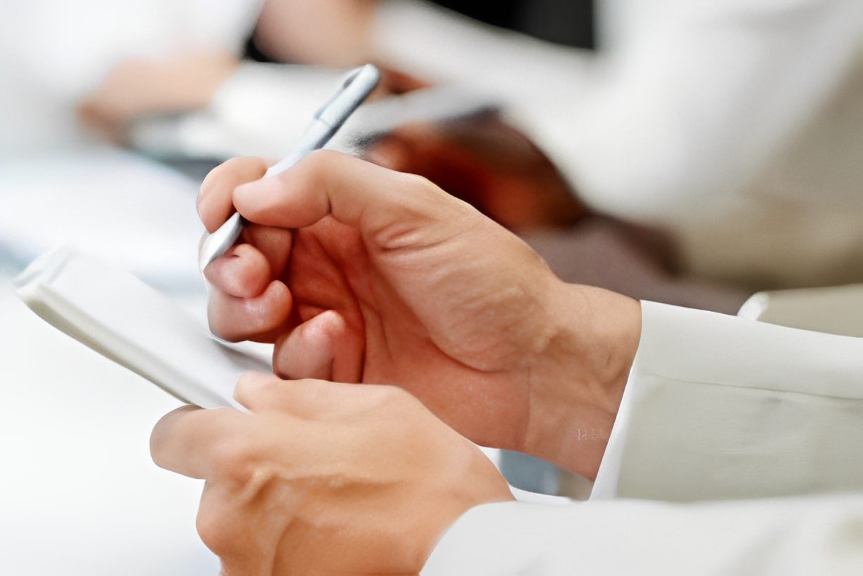 Person writing notes with a pen.
